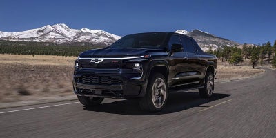 Black Chevrolet Silverado EV driving on road
