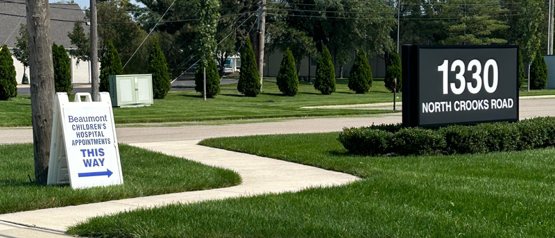 sign on the sidewalk directed where to go for beaumont children's hospital appointment